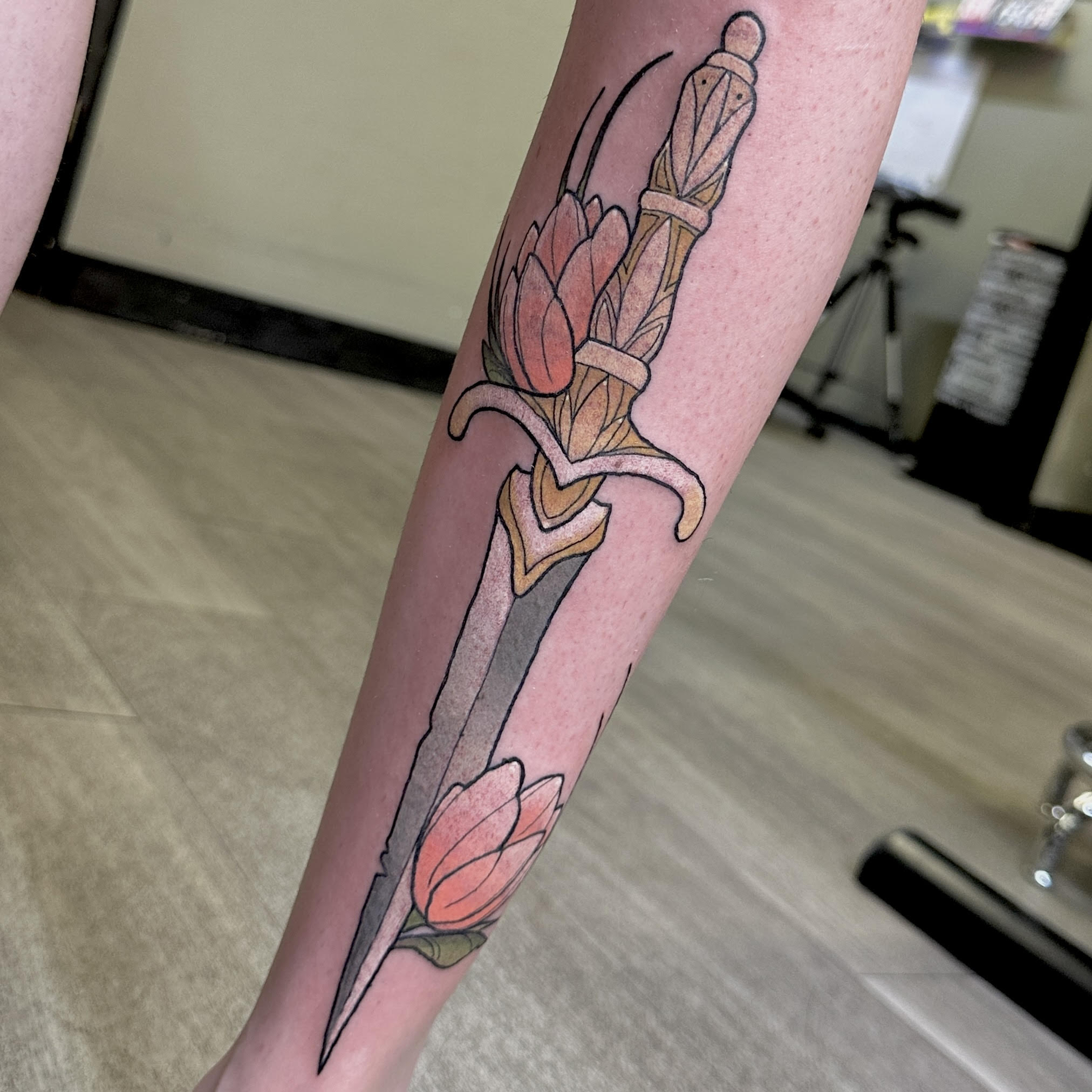 Neotraditional dagger with tulip flowers tattoo
